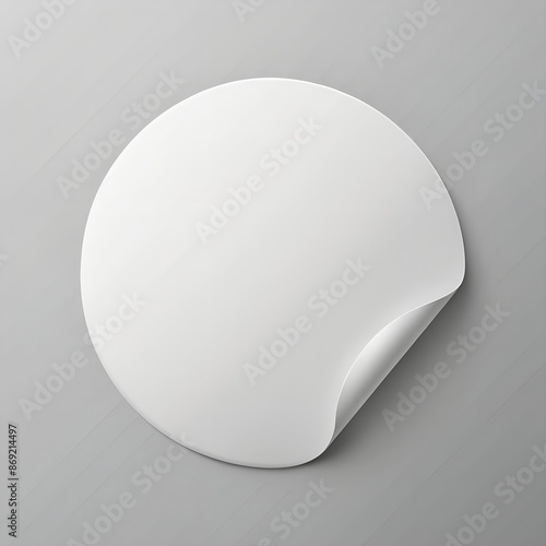 A realistic, round, white paper adhesive sticker mock-up on light grey background