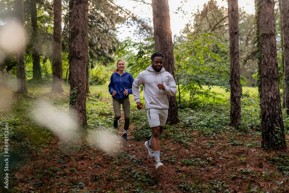 Two friends jogging through a dense forest area, sharing a moment of fitness and fun. They are dressed in sportswear, highlighting their active lifestyle. Two friends jogging through a dense forest area, sharing a moment of fitness and fun. They are dressed in sportswear, highlighting their active lifestyle.