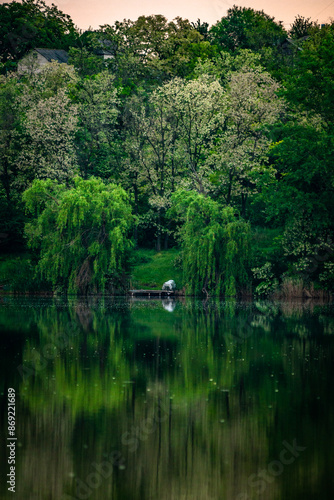 Sunset over the river . Another river beach. May and trees . Green colors . Reflections on water . Fising on river . Golden sunset 