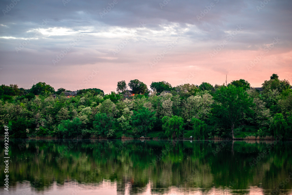 Obraz premium Sunset over the river . Another river beach. May and trees . Green colors . Reflections on water . Fising on river . Golden sunset 