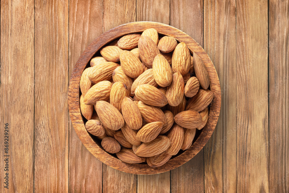 almond nuts peeled raw in bowl on wooden table background, top view. organic vegetarian food. almond nuts peeled raw in bowl on wooden table background, top view. organic vegetarian food.