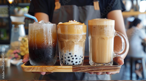 A photo shows someone holding out a tray with different types of cold coffee drinks, a hot drink, and an ice latte on top photo