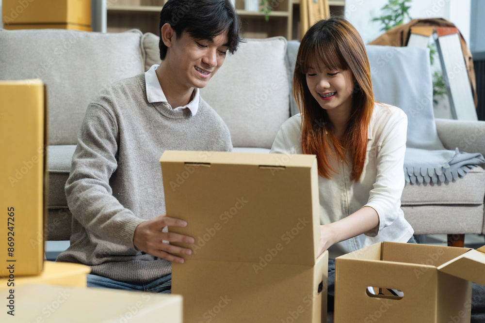 young couple helps put things in boxes and prepares to move to a new house. young couple helps put things in boxes and prepares to move to a new house.