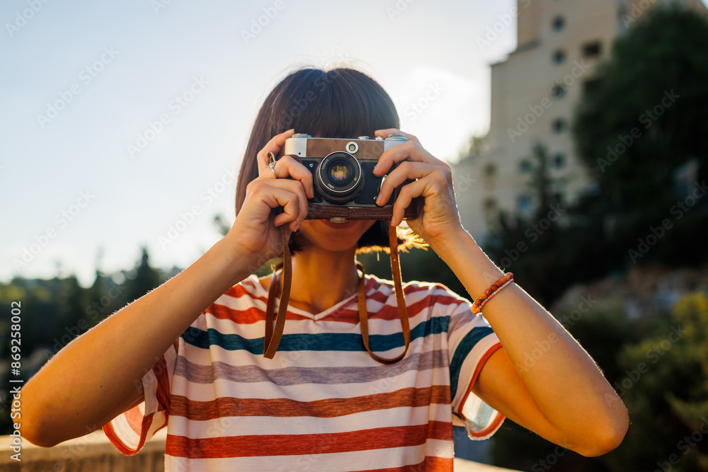Obraz premium young girl with a camera. photographer with camera. Stylish girl with a film camera. takes a shot.