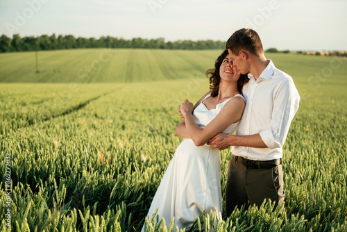 In formal wedding clothes. Lovely couple are on the agricultural field together photo