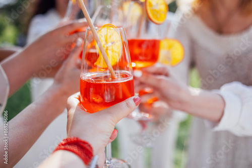 Canvas Print Close-up of a female hands with glasses with a delicious aperol