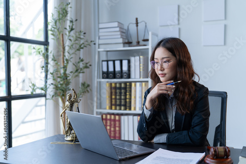 Картината върху платно A female attorney is diligently working at her desk in the office