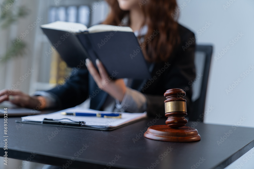 A female attorney is diligently working at her desk in the office. A female attorney is diligently working at her desk in the office.
