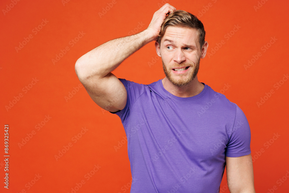 Young sad shocked confused puzzled unhappy man wear purple t-shirt casual clothes look aside hold scratch head look aside on area isolated on red orange background studio portrait. Lifestyle concept. Young sad shocked confused puzzled unhappy man wear purple t-shirt casual clothes look aside hold scratch head look aside on area isolated on red orange background studio portrait. Lifestyle concept.