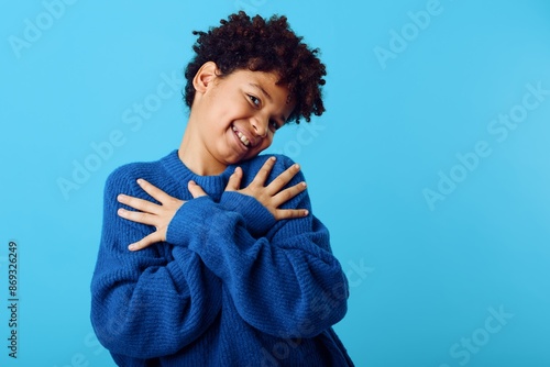 Slika na platnu A young african american boy in a blue sweater expressing emotional depth with h