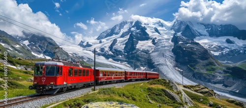 A red train is traveling through a snowy landscape. The train is surrounded by mountains and the snow is piled up on the ground. The scene is peaceful and serene © pector