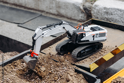 Photos radio-controlled toy on toy construction site, radio-controlled excavator, enter