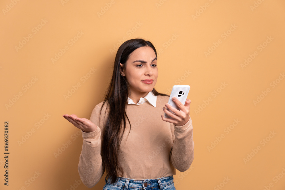 unhappy brunette young woman with sad face expression in all beige colors. app, social media, addiction, network concept. unhappy brunette young woman with sad face expression in all beige colors. app, social media, addiction, network concept.