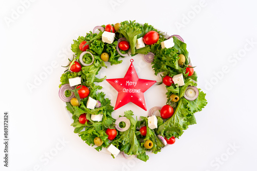 Close-up of the Christmas wreath salad with vegetables and feta cheese on the dark background. Selective focus