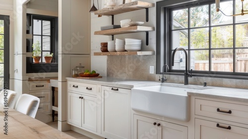 A contemporary kitchen with an open shelving concept, white cabinets, and a farmhouse sink.