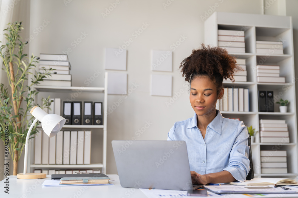 happy young businesswoman African American siting on the chiar cheerful demeanor raise holding coffee cup smiling looking laptop screen.Making opportunities female working successful in the office. happy young businesswoman African American siting on the chiar cheerful demeanor raise holding coffee cup smiling looking laptop screen.Making opportunities female working successful in the office.
