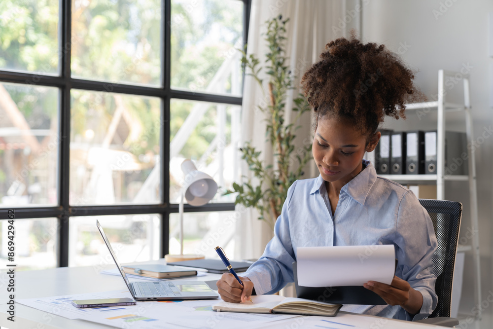 happy young businesswoman African American siting on the chiar cheerful demeanor raise holding coffee cup smiling looking laptop screen.Making opportunities female working successful in the office. happy young businesswoman African American siting on the chiar cheerful demeanor raise holding coffee cup smiling looking laptop screen.Making opportunities female working successful in the office.