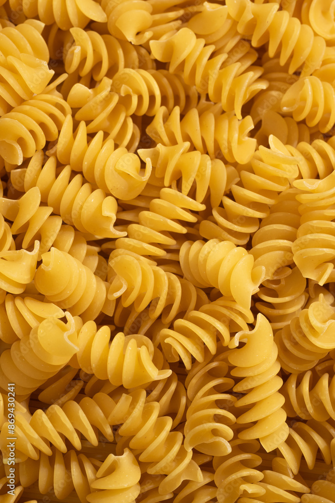 Close-up of raw, uncooked fusilli pasta. Pile of Italian pasta Close-up of raw, uncooked fusilli pasta. Pile of Italian pasta