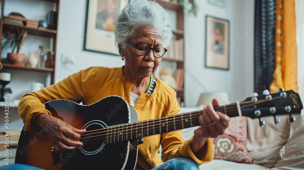Fototapeta premium Elderly woman playing acoustic guitar in cozy living room. Relaxed and casual mood captured. Perfect for lifestyle, music, and hobby themes. Ideal for inspiring creativity and passion. AI