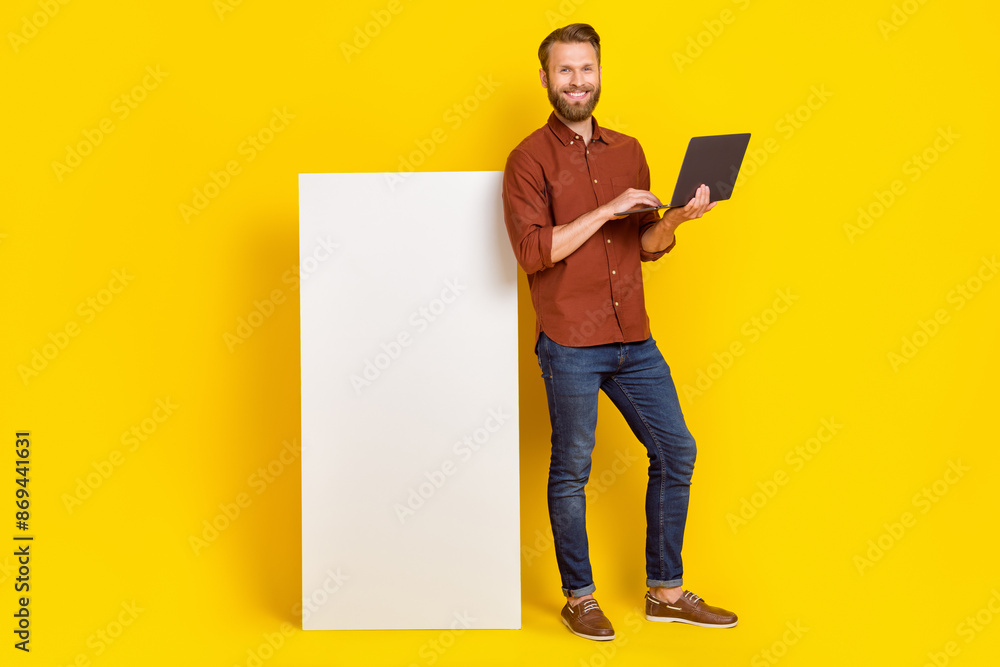 Full length portrait of cheerful person use wireless netbook big empty space telephone screen isolated on yellow color background Full length portrait of cheerful person use wireless netbook big empty space telephone screen isolated on yellow color background