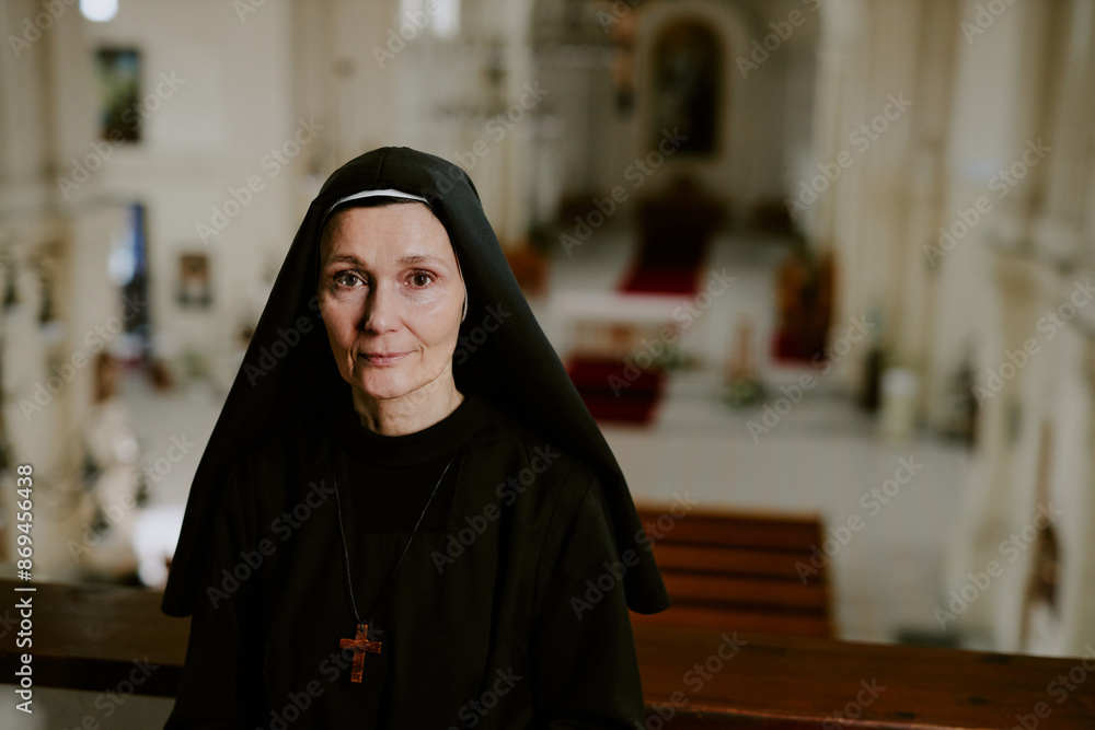 Portrait of mature Caucasian Catholic nun standing at mezzanine in church building, looking at camera, copy space Portrait of mature Caucasian Catholic nun standing at mezzanine in church building, looking at camera, copy space