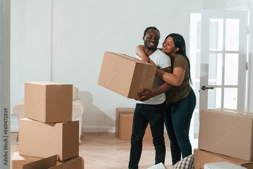 Holding boxes. African American couple are moving into new house Holding boxes. African American couple are moving into new house