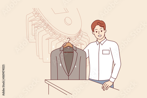Man working in dry cleaner shows business jacket, cleaned of stains from food or sauce. Dry cleaner manager smiles, inviting to become client and take advantage of services for caring for clothes