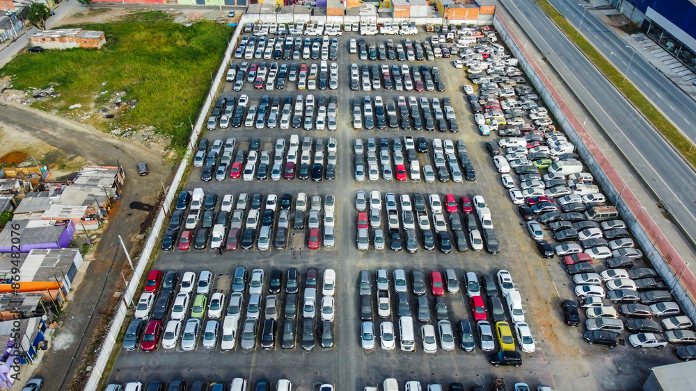 Visão aérea de um estacionamento com vários veículos estacionados, mostrando a organização e a distribuição dos carros em diferentes áreas do espaço Visão aérea de um estacionamento com vários veículos estacionados, mostrando a organização e a distribuição dos carros em diferentes áreas do espaço