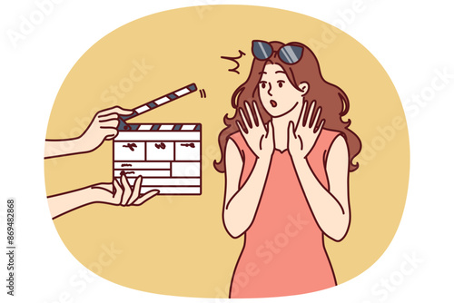 Woman movie star is embarrassed sees clapboard passing casting call for role in popular series or tv show. Movie star girl waving hands, not wanting to film or answer questions from reporters