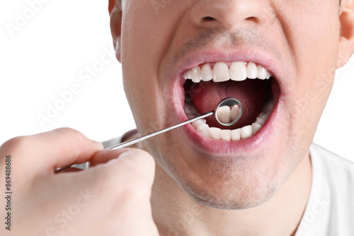 Dentist examining man's teeth and gums with mirror on white background, closeup photo