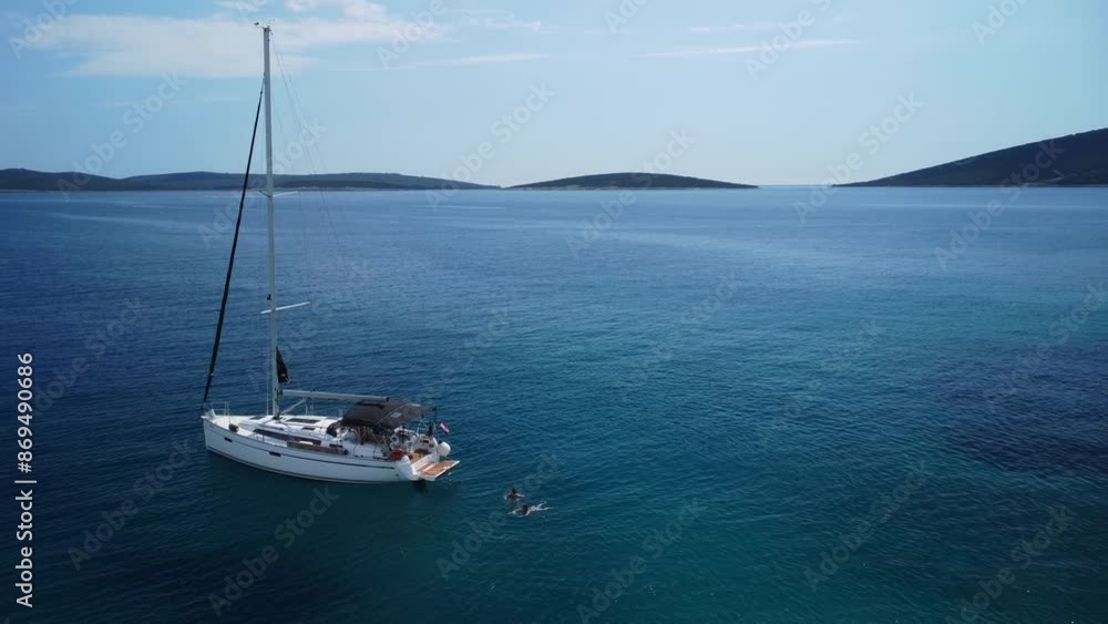 Two women swimming near sailing boat Two women swimming near sailing boat