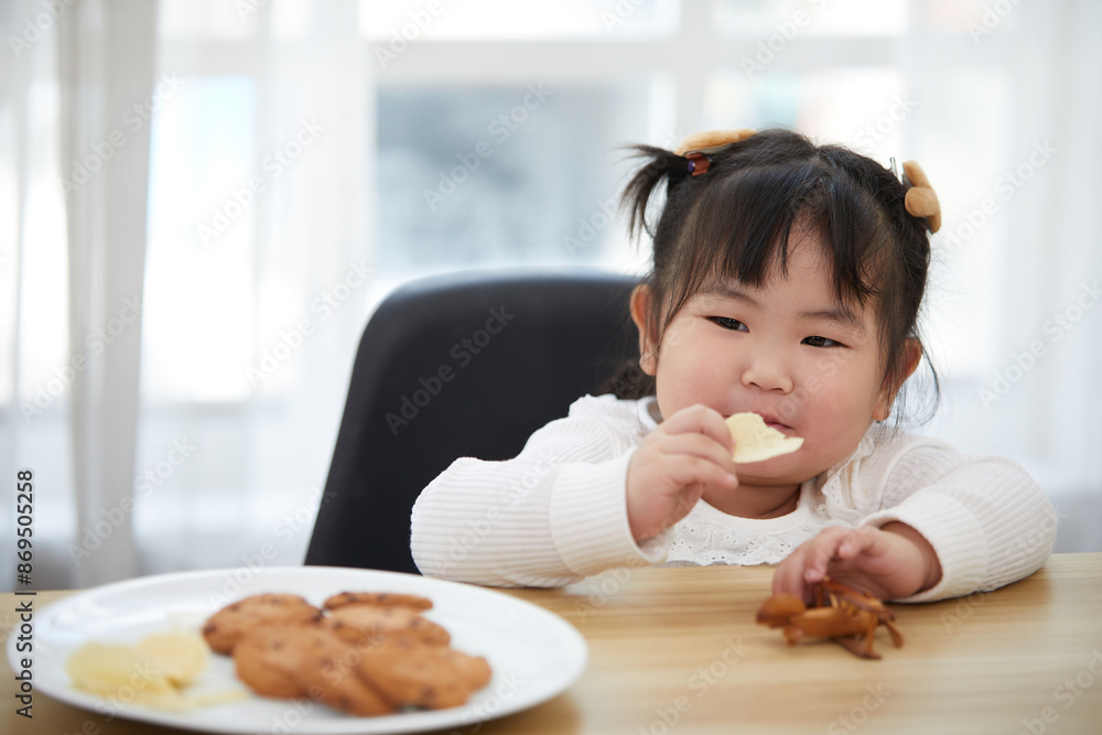 portrait child girl enjoy eating potato chips in the kitchen portrait child girl enjoy eating potato chips in the kitchen