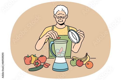 Elderly man uses blender and prepares smoothies from fresh fruits and vegetables in order to stay healthy. Retired man prepares smoothies and follows vitamin diet prescribed by nutritionist doctor