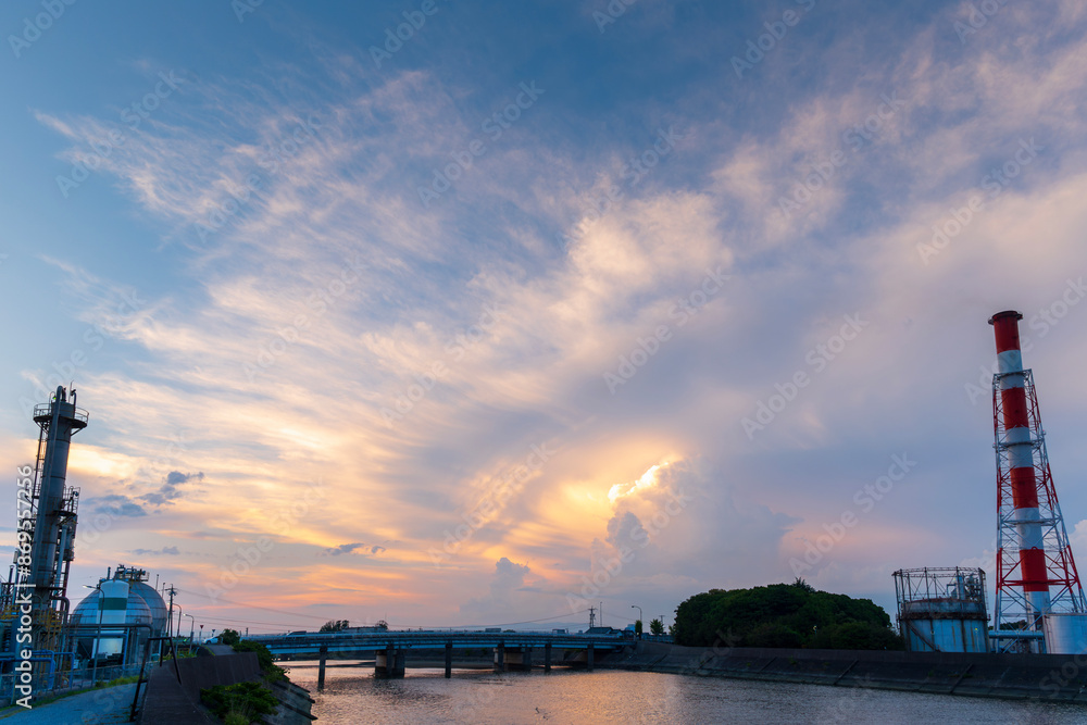 Naklejka premium Equipment of gas oil refining plant in Japan industrial factory area with sunset or sunrise sky background view from Fishing port, Yokkaichi, Mie Prefecture, Japan.