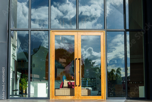 Glass door entrance to a large apartment hotel, the material is wood and steel, beautifully decorated.