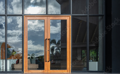 Glass door entrance to a large apartment hotel, the material is wood and steel, beautifully decorated.