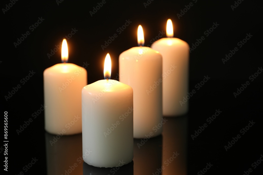 Many burning candles on mirror surface against black background Many burning candles on mirror surface against black background