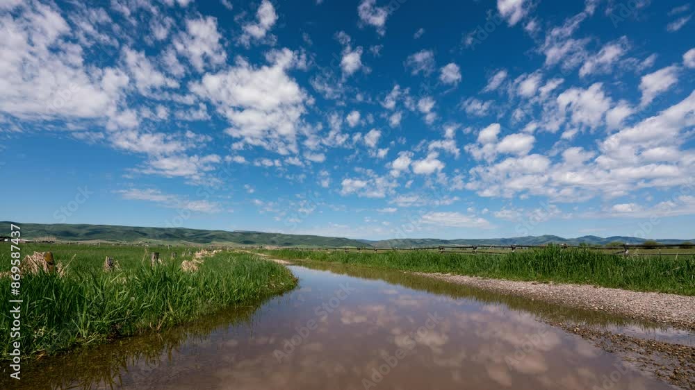 Timelapse of clouds reflecting in water in green marsh during the Spring. Timelapse of clouds reflecting in water in green marsh during the Spring.