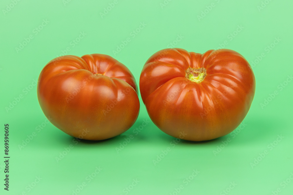 grosse tomate, en gros plan, sur un fond vert