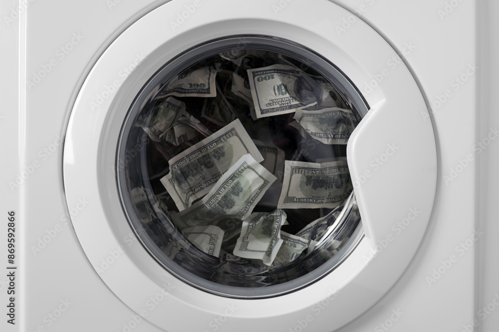 Hundred dollar bills inside the rotating drum of a washing machine. Dirty american paper money in the washing machine. Hundred dollar bills inside the rotating drum of a washing machine. Dirty american paper money in the washing machine.
