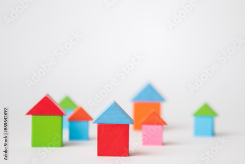 colorful wooden toy blocks or tiny wooden houses isolated on white background, business and house building concept