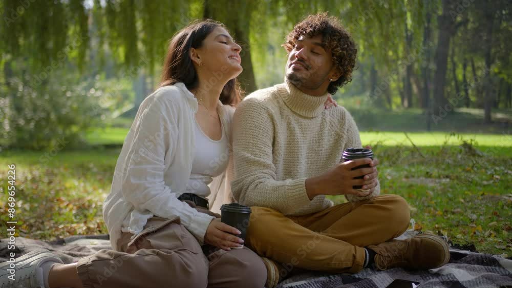 Happy smiling family carefree multiethnic couple in love Hispanic woman female Indian Arabian man male enjoying coffee romantic date. Girlfriend boyfriend have picnic talking hug park outdoors blanket Happy smiling family carefree multiethnic couple in love Hispanic woman female Indian Arabian man male enjoying coffee romantic date. Girlfriend boyfriend have picnic talking hug park outdoors blanket