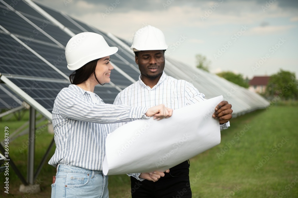 Male and female engineers worker working in solar panels power farm. technician working at solar power station Male and female engineers worker working in solar panels power farm. technician working at solar power station
