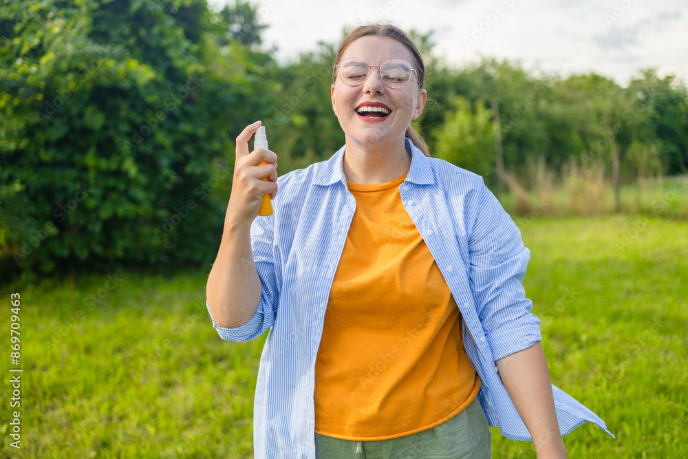 Woman spraying insect repellent or bug spray to her hand at park. High quality photo Woman spraying insect repellent or bug spray to her hand at park. High quality photo