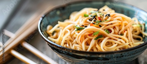 Bowl of noodles drizzled with soy sauce, with a background of a clear space for adding additional elements in the shot, known as a copy space image.