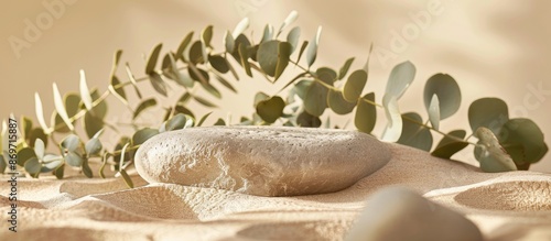 Minimalist stone podium atop sand with eucalyptus blur on beige backdrop, ideal product display with copy space image for skincare, jewelry, and cosmetics. photo
