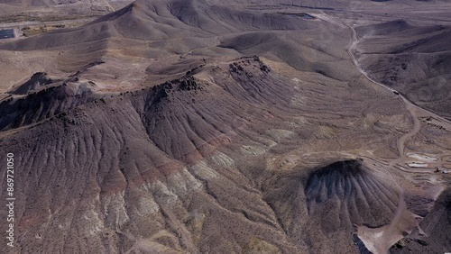 фотографія Veins of Civilization: Man-Made Intrusions into Nature, A winding road visible amidst desolate hills signifies humanity’s persistent presence even in nature’s most inhospitable settings