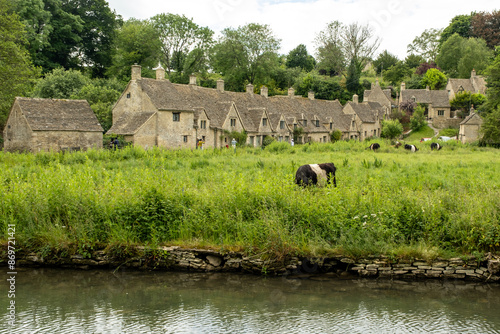 Row of cottages in Arlington, Bibury, Cotswold, was built in the late 14th century as a wool store and converted into weavers' houses in the late 17th century.  photo