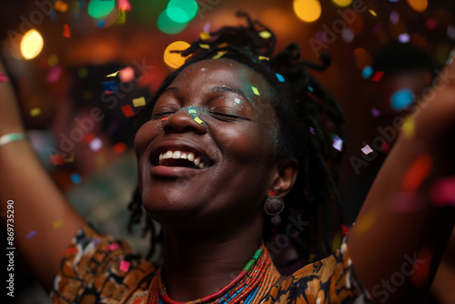A happy young woman smiling brightly, surrounded by colorful confetti during a festive celebration.