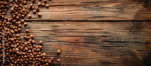 Wooden background with dry cat food providing copy space image.